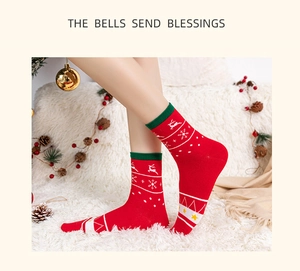 Detail of red Christmas crew socks featuring reindeer patterns on white plush background