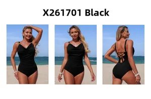 Black one-piece swimsuit featuring ruched details and criss-cross back straps on a beach