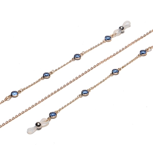 Detailed macro view of crystal glasses chain with blue beads and gold links