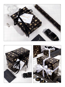 Detail of black gift wrapping paper with gold foil heart and crown patterns and accessories