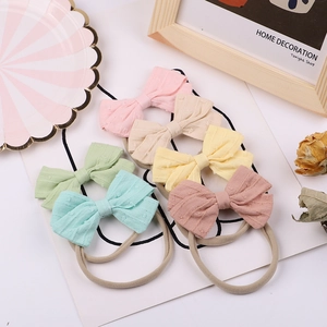 Soft nylon baby headbands with macaron bows in six morandi colors on white display