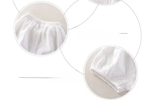 Détails de la taille élastique et des ourlets de jambe sur le bloomer bébé blanc