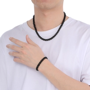 Set collana e bracciale in acciaio inossidabile nero lucido indossato da un modello