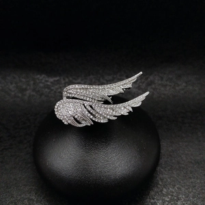 Macro shot of silver wing brooch with full crystal inlay on a professional black stand