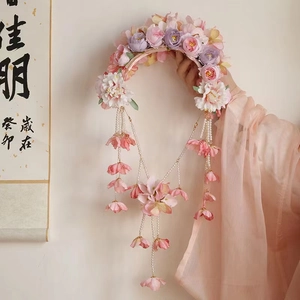 Detail eines Blumen-Haarreifs mit Seidenblumen und langen Perlenquasten im Retro-Stil