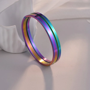 Detalle macro de pulsera de acero inoxidable arcoíris con ranura sobre cerámica blanca fina
