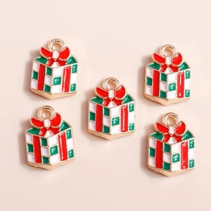Détail de cinq pendentifs émaillés en forme de cadeaux de Noël sur fond beige