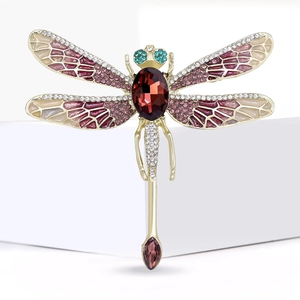 Elegant gold-tone dragonfly brooch with red rhinestones and pink enamel on a white base