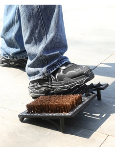 Detail of heavy-duty cast iron shoe scraper with stiff bristles for outdoor cleaning