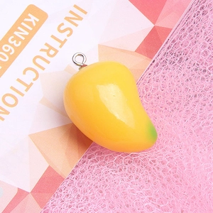 Macro shot of 3D yellow mango resin pendant with green gradient and metal loop