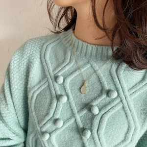 Elegant gold-plated water drop pendant necklace with white shell on mint sweater