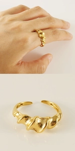 Macro detail of adjustable golden twisted ring showing sleek spiral design on woman's hand