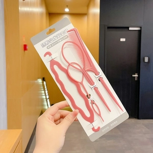 Set of pink hair styling tools including tail comb and topsy tail loops on packaging