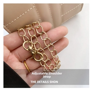 Close-up of golden metal chain strap with adjustable hook on beige crossbody bag