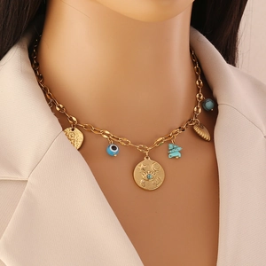 Détail d'un collier bohème doré avec pierres turquoises et pendentifs mauvais œil sur modèle