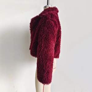 Dettaglio della texture in ecopelliccia bordeaux su una giacca invernale corta