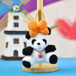 Detail view of cute plush panda keychain featuring an orange bow and crystal pendant