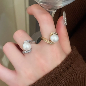 Détail de bagues serpent plaquées or avec perles et zircons portées par un mannequin