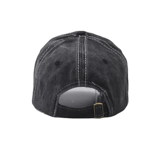 Detail view of washed black cotton baseball cap with white contrast stitching and metal buckle