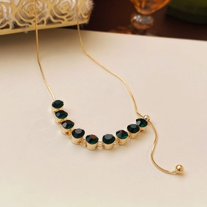 Dettaglio del pendente in zirconia verde smeraldo su catena a serpente dorata regolabile