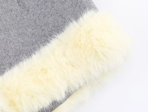 Detail view of gray knit fabric with plush off-white faux fur trim on winter jacket