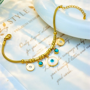 Golden snake chain bracelet featuring white evil eye pendant and turquoise beads