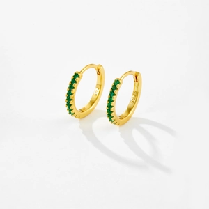 Macro detail of gold S925 sterling silver hoop earrings with inlaid green zircons