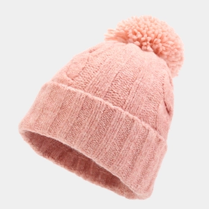Close-up of pink knit beanie with cable pattern and large fluffy pom-pom detail