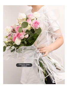 Detail of waterproof flower wrapping paper with pink roses and elegant lace ribbon trim