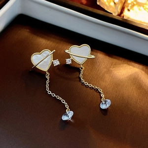Macro shot of gold heart planet earrings with zircon fringe and mother-of-pearl inlay
