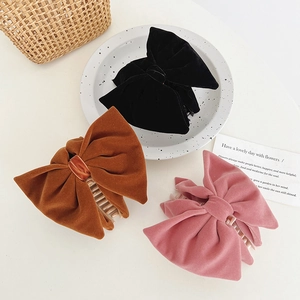 Detail of velvet bow hair claws in black, brown, and pink with resin teeth