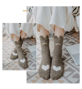 Close-up of brown coral fleece socks featuring cat ear cuffs and white heart pattern