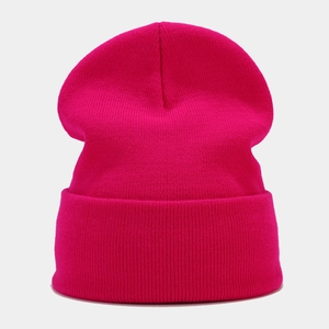 Close-up of ribbed knit texture on a vibrant magenta winter beanie with folded cuff