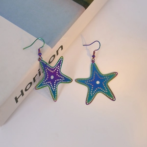 Detail of colorful laser starfish earrings with hollow metal texture and iridescent finish