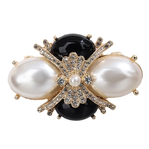 Vintage style gold brooch with white pearls, black accents, and sparkling rhinestones