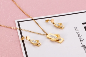 Close-up of gold Roman numeral necklace and earrings set with rhinestones on a card