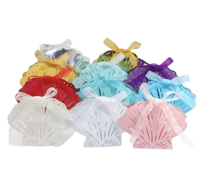 Laser-cut shell candy boxes in various colors with elegant ribbon bows for wedding favors