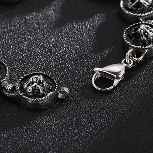 Macro detail of silver stainless steel bracelet featuring embossed bulldog charms and lobster clasp