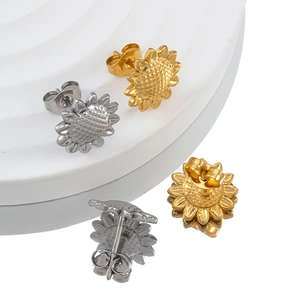 Gold and silver sunflower stud earrings in stainless steel on minimalist display