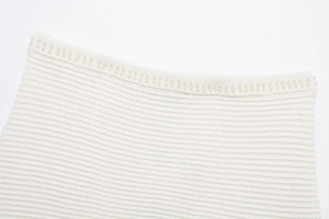 Détail du col d'une robe en tricot blanc orné de perles délicates et raffinées