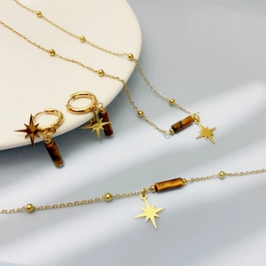 Golden 18K titanium jewelry set with brown natural stones and star charms on silk fabric