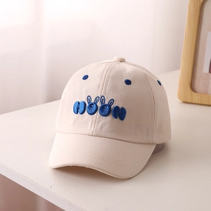 Detailed close-up of beige toddler baseball cap featuring blue rabbit ear embroidery