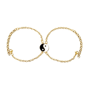 Detailed view of gold chain bracelets with black and white Yin Yang enamel charms