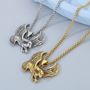 Detailed macro of gold and silver eagle pendants with box chains and feather textures