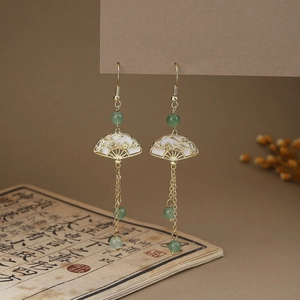 Detail of Chinese style butterfly fan earrings with green beads and long metal tassels