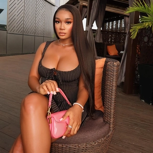 Chic pinstripe dress set with a pink clutch bag shown in a stylish outdoor setting