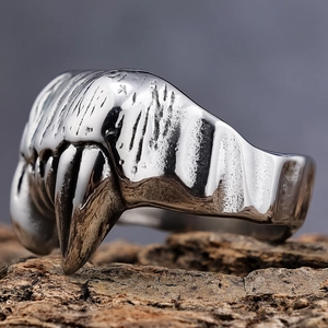 Macro shot of silver gothic beast fangs ring on textured bark backdrop