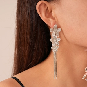 Silver vintage flower tassel earrings with rhinestone accents on a female model