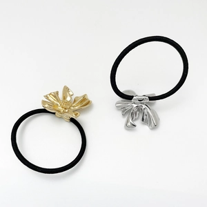 Detailed shot of elastic hair ties with gold flower and silver bow metal charms