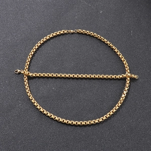 Vista macro di set collana e bracciale in acciaio inossidabile dorato a maglia box